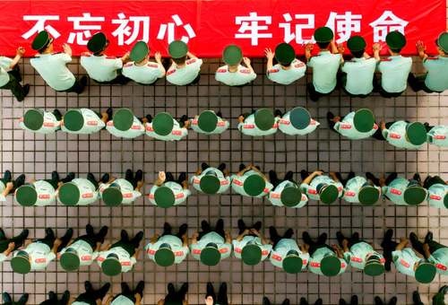 نیروهای نظامی چین در جشن نودوهشتمین سالگرد تاسیس حزب کمونیست چین، نام خود را روی بنر بزرگی می‌نویسند./ شنزن