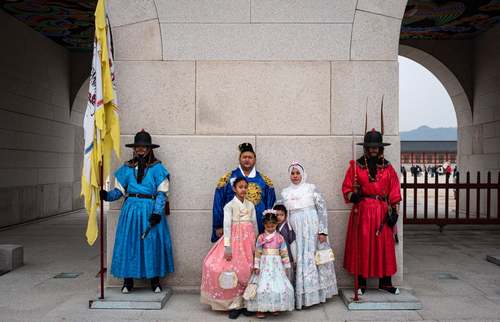 گردشگران با لباس سنتی کره در حال گرفتن عکس در یک قصر تاریخی در شهر سئول کره جنوبی/ EPA