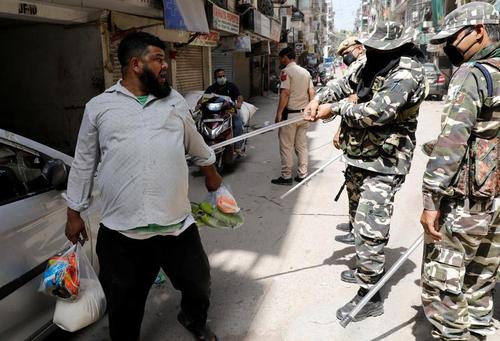 پلیس هند در حال کتک زدن افرادی که حکم قرنطینه سراسری را نقض کرده‌اند. دهلی/ رویترز