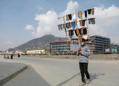 نوجوان افغان در حال فروش ماسک  در شهر کابل/ رویترز