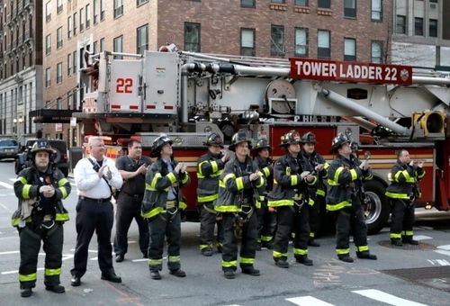 آتش‌نشانان نیویورکی در مقابل بیمارستانی در این شهر جمع شده‌اند و کادر درمانی را تشویق می‌کنند./ EPA
