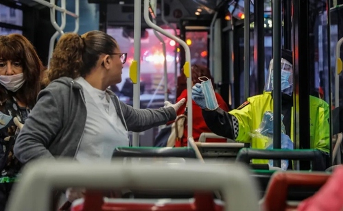 اعطای ماسک از سوی پلیس اسپانیا به یک مسافر اتوبوس در نخستین روز کاری پس از تعطیلات عید پاک و قرنطینه سراسری/ مادرید/ گتی ایمجز