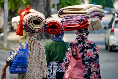 زنان دستفروش در حال فروش تشک‌های دستباف در 