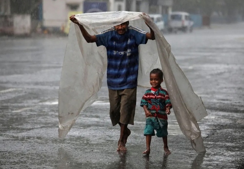 مرد بی‌خانمان هندی و فرزندش زیر باران شهر کلکته/ رویترز