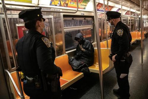 پلیس مترو نیویورک در حال بیدار کردن یک مسافر خوابیده در واگن مترو/ رویترز