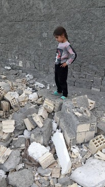 کودکی که به همراه خانواده‌اش در یکی از خانه‌های تخریب‌شده شهرک فدک زندگی می‌کرد، حالا به خرابه‌های خانه‌شان نگاه می‌کند.