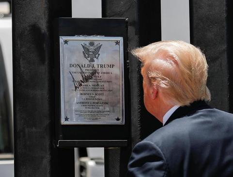 ترامپ در حال قرائت متن تابلو یادبود دیوار مرزی 200  مایلی ساخته شده به دستور او در مرز با مکزیک در ایالت آریزونا آمریکا/ رویترز