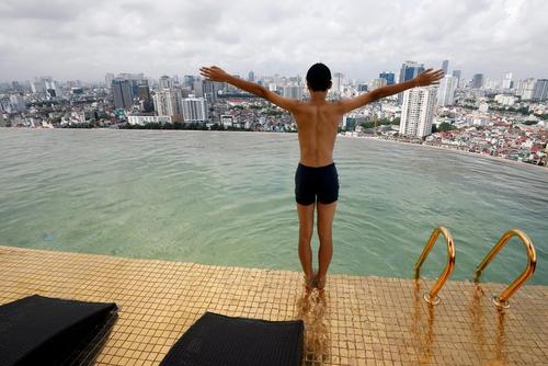 شنای یک مسافر در استخر نخستین هتل با روکش طلا در جهان در شهر 