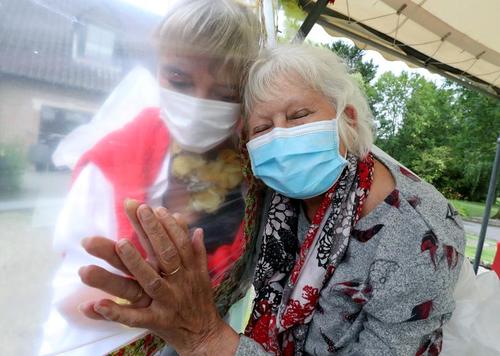 مدیر یک خانه سالمندان در بلژیک یک پیرزن 83 ساله را از بیم ویروس کرونا از پشت دیوار نایلونی در آغوش گرفته است./ رویترز