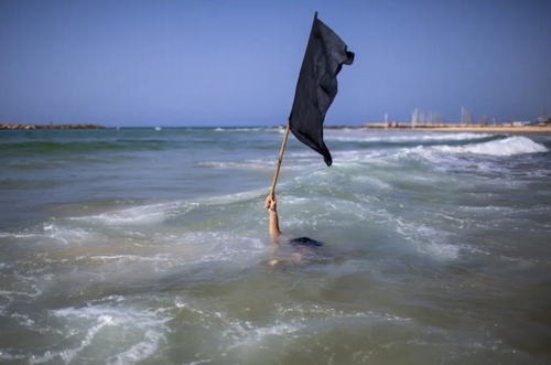 ورود مردی با پرچم سیاه به ساحل شهر تل‌آویو برای اعتراض به تصمیم دولت برای قرنطینه سراسری 3 هفته‌ای و تعطیلی ساحل/ آسوشیتدپرس