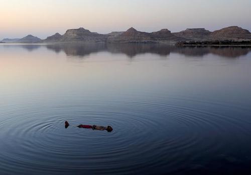 شنای مرد مصری در دریاچه‌ای در صحرای غربی مصر/ رویترز