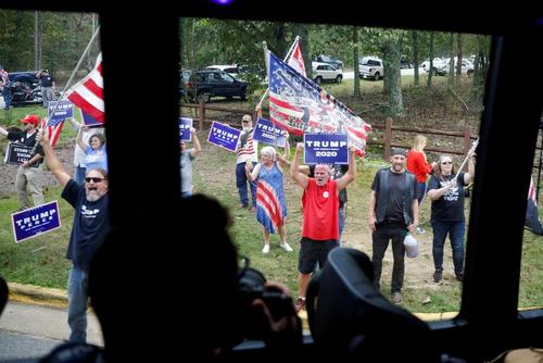 شعار دادن و تجمع گروهی از حامیان ترامپ در مقابل اتوبوس‌های کاروان حامل 