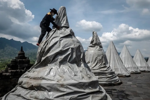 پوشاندن مجسمه‌های معبدی در جاوه اندونزی برای در امان ماندن آنها از غبارهای آتشفشانی/ گتی ایمجز