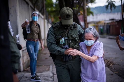 کمک یک سرباز به یک پیرزن در مقابل یک مرکز رای‌گیری در انتخابات پارلمانی ونزوئلا در شهر والنسیا ونزوئلا/ زوما