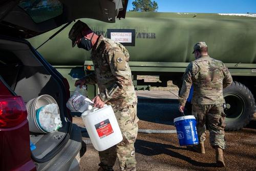 نیروهای گارد ملی آمریکا در حال توزیع اب آشامیدنی بین مردم ایالت می سی سی پی آمریکا. بسیاری از بخش های این ایالت آمریکا به دلیل توفان برفی از 3 هفته پیش با مشکل قطعی آب روبروست./ رویترز