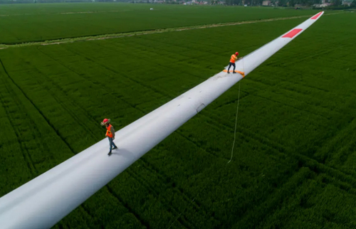 کارگران در حال کار روی پره های یک توربین بادی در چین/ گتی ایمجز