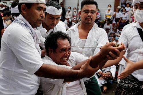 مرد هندو در بالی اندونزی در چارچوب یک مراسم آیینی در حال فرو کردن یک خنجر به پیشانی خود است./ رویترز