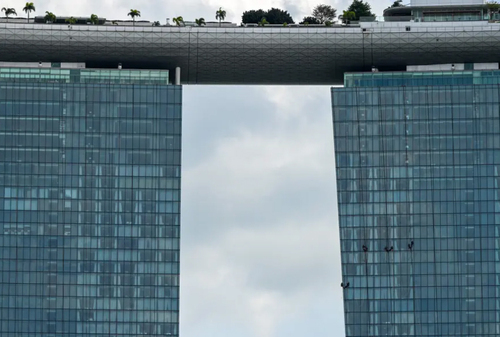 کارگران در حال تمیز کردن نمای شیشه ای هتلی در سنگاپور/ خبرگزاری فرانسه