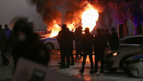 آتش زدن خودروی پلیس از سوی معترضان در جریان اعتراضات دیشب در شهر آلماتی/ رویترز