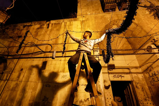 جوان فلسطینی در شهر قدس در حال تزیین محله به مناسبت آغاز ماه مبارک رمضان/ رویترز