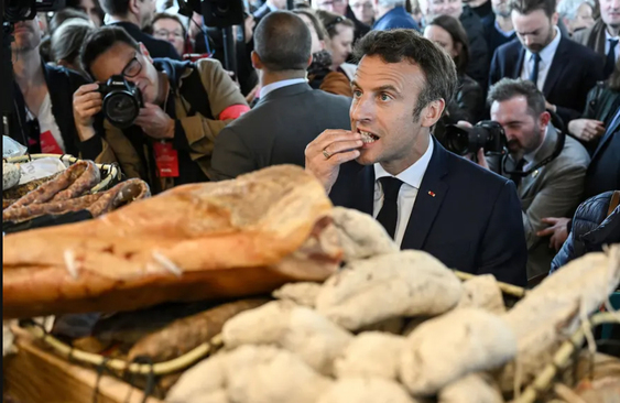 رییس جمهوری فرانسه در حال تست نان در یک بازار/ رویترز
