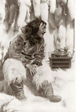 مردی بومی در حال گوش دادن به موسیقی که از یک دستگاه گرامافون پخش می شود. (1922) 
