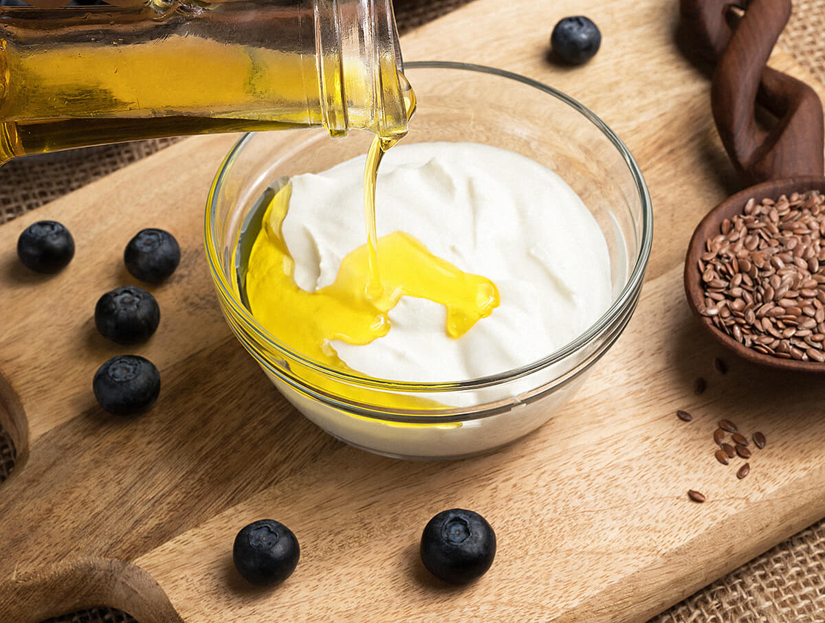 ترکیب پنیر کاتیج و روغن بذر کتان همراه با میوه بلوبری و یک قاشق بذر کتان